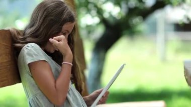 Tablet bilgisayarı olan kız. Tablet PC 'de güzel bir kız oyunu oynuyor. Tablet-PC 'si olan hoş bir kız bankta oturuyor. Gerçek samimi duygular. Tablet bilgisayarı olan güzel bir kız. Oyundan büyülenmişti.