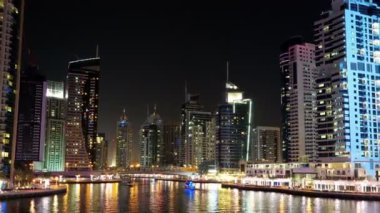 UHD 4K Dubai Marina gecesi zaman aşımına uğrayın, Birleşik Arap Emirlikleri. Dubai Marina - dünyanın en büyük insan yapımı marinası, Basra Körfezi 'nin 3 km' lik kıyı şeridi boyunca oyulmuş bir kanal kentidir.
