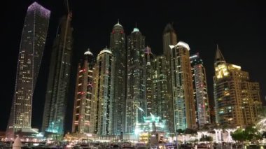 UHD 4K Dubai Marina gece yakınlaştırması, Birleşik Arap Emirlikleri. Dubai Marina - dünyanın en büyük insan yapımı marinası, Basra Körfezi 'nin 3 km' lik kıyı şeridi boyunca oyulmuş bir kanal kentidir.