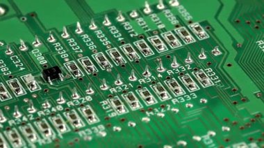 Elektronik bileşenli yeşil çip. Mikro devre, rezistanslar ve çipler. Yeşil devre kartındaki çip ve rezistanslar kapanıyor. Elektronik devre kartı, makro lens kapat