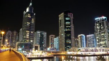 4K Dubai Limanı gece vardiyası, Birleşik Arap Emirlikleri. Dubai Marina, dünyanın en büyük insan yapımı marinası. Dubai Marina, Basra Körfezi 'nin 3 km' lik bir kıyı şeridi boyunca oyulmuş bir kanal kentidir.