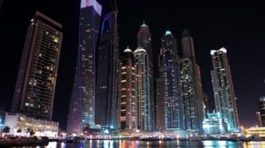 4K Dubai Limanı gece vardiyası, Birleşik Arap Emirlikleri. Dubai Marina, dünyanın en büyük insan yapımı marinası. Dubai Marina, Basra Körfezi 'nin 3 km' lik bir kıyı şeridi boyunca oyulmuş bir kanal kentidir.