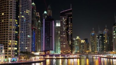 4K Dubai Limanı gece vardiyası, Birleşik Arap Emirlikleri. Dubai Marina, dünyanın en büyük insan yapımı marinası. Dubai Marina, Basra Körfezi 'nin 3 km' lik bir kıyı şeridi boyunca oyulmuş bir kanal kentidir.