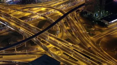 Sinemagraf. Gece Dubai şehir merkezi trafiği, Birleşik Arap Emirlikleri. Şeyh Zayed yolu Dubai 'deki Burj Halife gökdeleninin 124. katından, şu anda dünyanın en yüksek binası olan 829 metre.