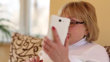 Kadın akıllı telefonla iletişim kuruyor. Beyaz akıllı telefonlu sarışın kadın. Cep telefonundaki kadın konuşmaları
