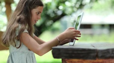 Oyun bağımlılığı. Tablet bilgisayarı olan kız. Tablet PC 'de güzel bir kız oyunu oynuyor. Gerçek samimi duygular. Tablet bilgisayarı olan güzel bir kız. Oyundan büyülenmişti.