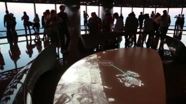 BAE, DUBAI, JANUARY 31, 2016: Birleşik Arap Emirlikleri, Dubai 'deki Burj Khalifa megatall gökdeleninde 125 kattaki interaktif harita yakınındaki insanlar. Yerden 456 metre yukarıda.