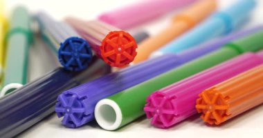 Plastik çok renkli keçeli kalemler beyaz bir masanın üzerinde.