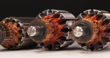 İki perküsyon masaj aleti ve daldırma blendırından gelen bakır bobinli üç pervane motor siyah arkaplanda dönüyor. Sinema 4K 60fps yakın çekim video