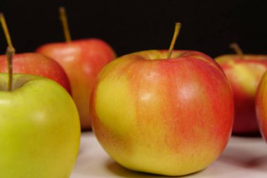 Siyah arka planda taze sulu kırmızı ve sarı elmalar