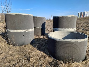 Açık hava şantiyesi. İnşaat işleri için güçlendirilmiş beton halkalar. Güçlendirilmiş beton halkalar kuyu yapımında kullanılan özel yapılardır. Su ve kanalizasyon