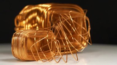 Siyah arkaplandaki elektrik akımı transformatörlerinden farklı boyutlarda bakır sargılar. Bakır, cuprum - kimyasal element, demir olmayan metal