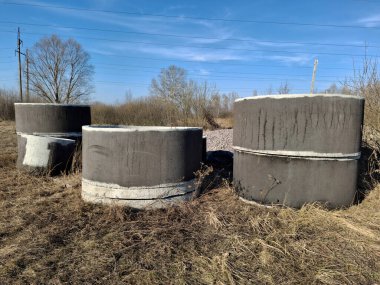 İnşaat işleri için farklı çaplarda güçlendirilmiş beton halkalar. Güçlendirilmiş beton halkalar kuyuların inşası için özel yapılardır. Su ve kanalizasyon, açık hava.