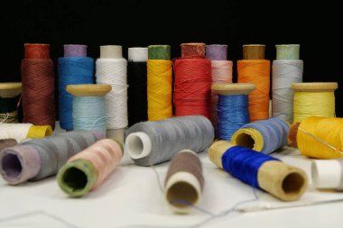 Çok renkli iplikler var. Masada çok renkli ipliklerin maketleri var