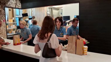 KYIV, UKRAINE, 16 Ağustos 2025: Kyiv şehrindeki McDonalds fast food restoranının içindeki insanlar. İşçiler emirleri kabul edip dağıtıyorlar.