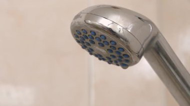 Duşta suyu açıp kapamak. Duş başlığından su akar. Banyoda duş başlığı, krom musluk, yakın çekim video.