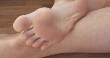 Güzel erkek ayağı. Adam ayak parmaklarını oynatıyor. Erkek ayağının tabanı. Seksi ayak ve yetişkin bir adamın parmakları, bir dakika rahatlama videosu. Sinema 4K 60fps video