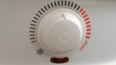 Kazanda soğuk su ısıtma düzenleyicisi. Adam ısıtıcıyı çalıştırıyor. Kırmızı ışık göstergesi açık, kazan sıcak suya döndü. Su ısıtıcısı, soğuk su tedarik sisteminden su ısıtır.