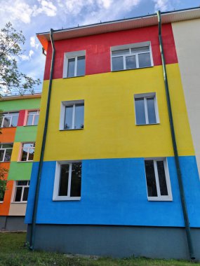Renkli duvarları olan bir okul binası. Okul binasının çok renkli yüzü
