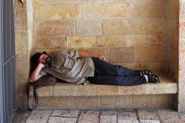 İsrail, Kudüs 'te taş bir bankta uyuyan bir adam.