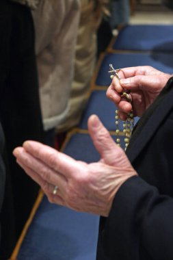 Elderly hands praying with Rosary Beads clipart