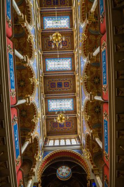 Dekoratif desenli kemerli bölümler, vitraylı pencereler ve asılı lambalar, simetrik ve detaylı bir mimari bakış açısı, Kudüs sinagogu,