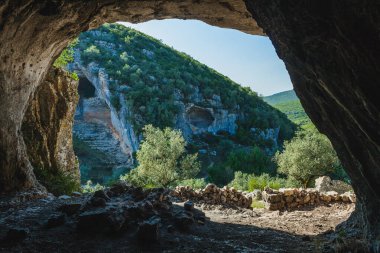 Buracas do Casmilo, Portekiz 'de doğal bir oluşum, kayalık bir yamaçta büyük mağaralar var. Bu mağaralar yemyeşil yapraklar ve zeytin ağaçlarının arasından geçen toprak bir patika ile bereketli bir araziye kurulmuştur. Işıklandırma şu şekilleri vurgular: 