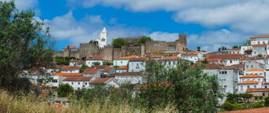 Terracotta çatılarının bir araya getirildiği geleneksel beyaz duvarlı evlerin karışımı ile Penela kasabasının büyüleyici bir manzarası. Kasabanın üstünde taş duvarları olan tarihi bir kale duruyor. Sahneye ortaçağ dokunuşu katıyor.