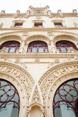 Lizbon 'daki Rossio Tren İstasyonu' nun dekoratif görünüşü Neo-Manueline mimarisinin karmaşık ayrıntılarına odaklanıyor. Tanınmış kemerler detaylı taş oymalarla süslenmiş, Gotik ve Rönesans etkisi sergiliyor.