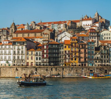Bu fotoğraf Porto, Portekiz 'in tarihi Ribeira bölgesini Douro Nehri' nin karşısından gösteriyor. Resim, geleneksel kırmızı kiremitli çatıları ve çeşitli cepheleriyle Porto 'nun yoğun, renkli binalarını ön plana çıkarıyor..