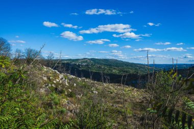 Portekiz, Vila de Ponte 'deki bir tepenin manzarası, dağınık beyaz bulutlarla temiz bir gökyüzünü gösteriyor.