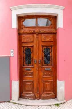 Eğri kemer ve zıt taş çerçeve zarafet eklerken, çevreleyen duvar ve fayanslı kaldırım manzaraya temiz, kentsel bir estetik veriyor.