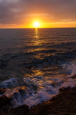 Nefes kesen bir okyanus gün batımı. Güneş ufukta belirdi. Suyun üzerinde altın bir parıltı bıraktı.