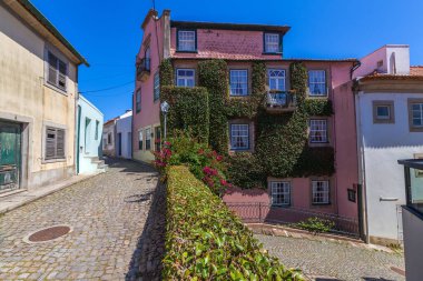 Porto, Portekiz 'de klasik Portekizli azulejolar (seramik fayanslar) ile süslenmiş küçük, geleneksel bir ev içeren büyüleyici bir sokak sahnesi.).