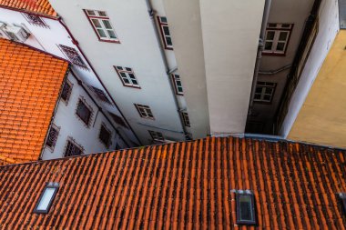 Kırmızı kiremitli çatıları olan renkli binalar arasındaki dar bir dar sokağa kuş bakışı bir bakış.