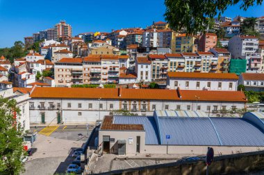 Portekiz 'in tarihi Coimbra şehrinin panoramik manzarası, kendine özgü kırmızı kiremitli çatıları ve büyüleyici mimarisi.