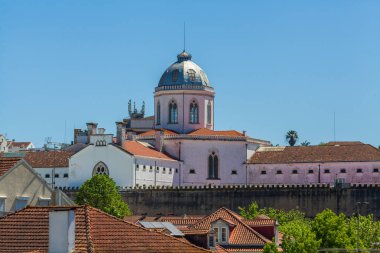 Kendine özgü pembe cephesi ve mavi gökyüzüne karşı duran kulesi olan tarihi bir bina.