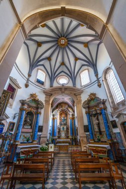 Kubbeli tavanı, süslü sunağı ve ahşap sıraları olan tarihi bir kilisenin içi.