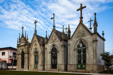 stone mausoleums with Gothic architectural details, including pointed arches, intricate carvings, and multiple crosses that stand prominently atop each structure clipart