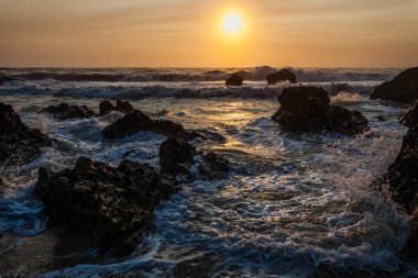 Yumuşak kum, ayak izleriyle işaretlenmiş, ön planda uzanıyor.