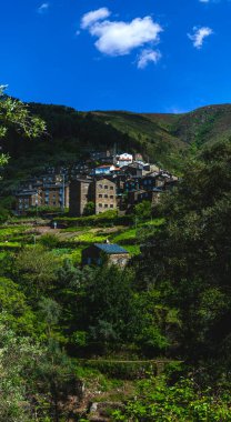 Yeşilliklerin arasına yerleşmiş geleneksel taş evleri olan Portekiz yamaç köyü