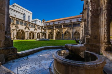 Huzurlu bir manastır avlusu kemerli yollar, canlı yeşillikler ve merkezi bir çeşme tarihi mimari ve doğal güzelliğin barışçıl bir karışımını oluşturuyor.