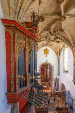 Büyük bir boru orgu, karmaşık oymalar, vitray camlar ve zengin dini sanatlar sergileyen canlı bir sunak içeren süslü bir kilise iç mimarisi.