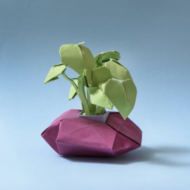 Açık mavi arkaplanda origami çiçeği. Yapraklar küçük kalpler gibidir.