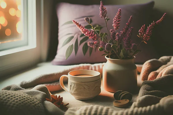 Cozy winter morning scene with hot coffee, blanket, candle lights, and heather and lavender flowers. Swedish concept of hygge is perfectly with copy space available for your own text.