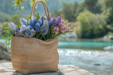Sümbül ve karanfil çiçekleriyle dolu bir saman torbası yumuşak sabah ışığının yumuşak kucaklamasının altında el dokuması bir doku sergiliyor.