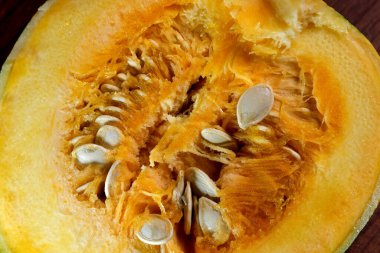 Küçük, tatlı, olgun bir balkabağı kahverengi, ahşap bir masanın üzerinde uzanıyor.