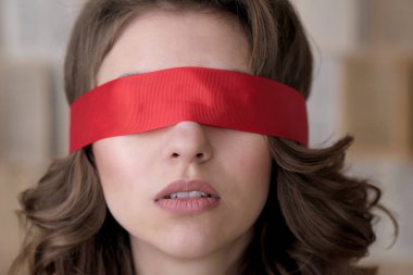 Genç, kahverengi saçlı, uzun dalgalı saçlı, kırmızı gözlü bir kadının portresi.