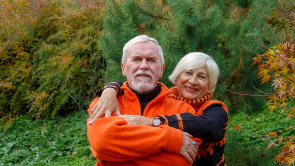 高齢者白髪楽観的なカップル男と女で秋にオレンジセーター — ストック写真