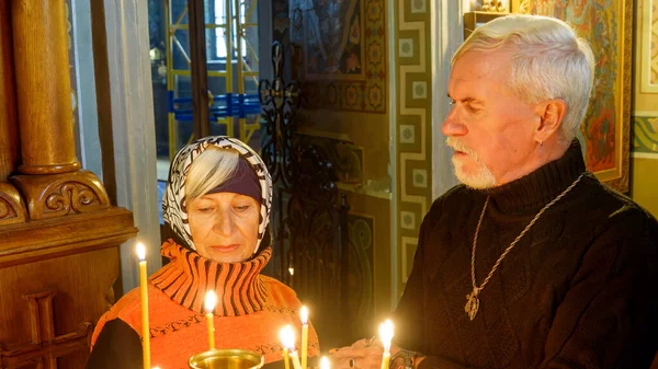 幸せな美しい高齢者は正教会の教会でキャンドルと白髪の夫婦 — ストック写真